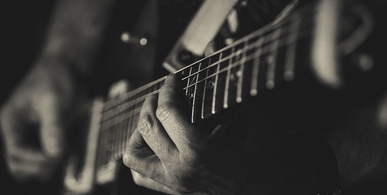 Jackie Washington Day black and white photo of a person playing an acoustic guitar
