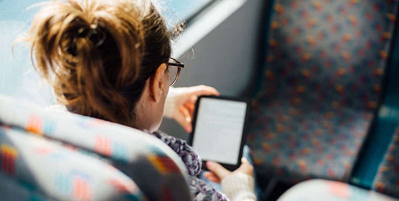 Libby female reading an ebook on a train