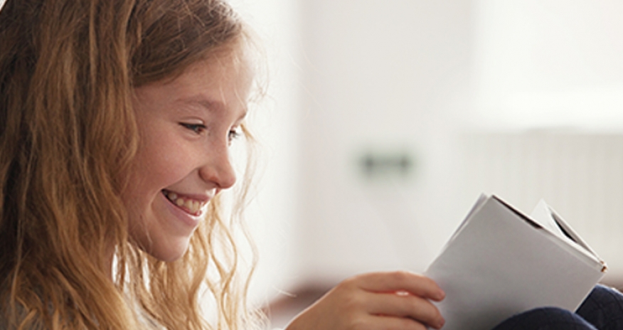 Central Tween Book Club smiling girl reading a book
