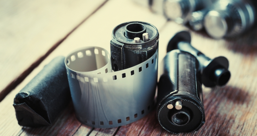Digitize your Memories A roll of film negatives and a camera sitting on a table