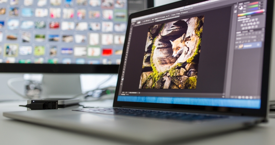 Photo Editing A computer with photo editing software displayed on the keyboard