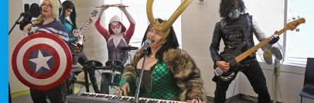 5 people dressed as super heroes playing instuments