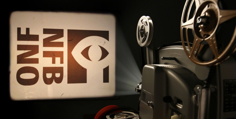 Photo of a film projector projecting the National Film Board logo onto a wall