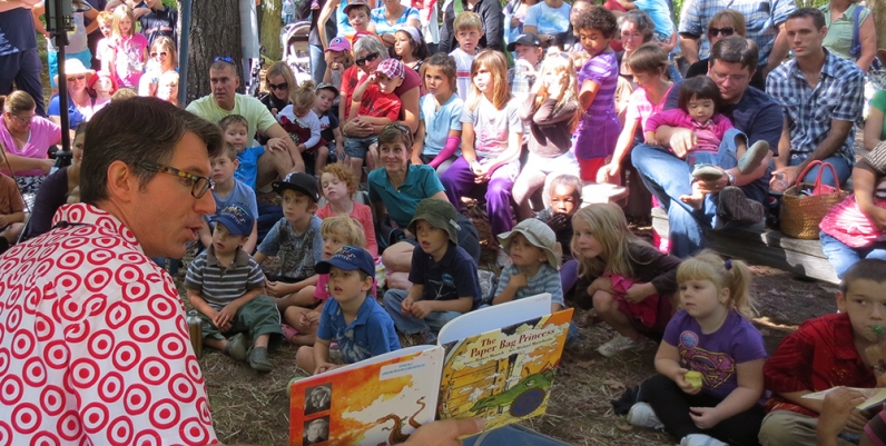 Man reading a story to a group of children at the Telling Tales Festival