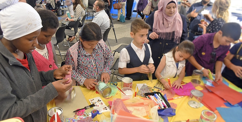 People gathered around a table doing crafts and activities.