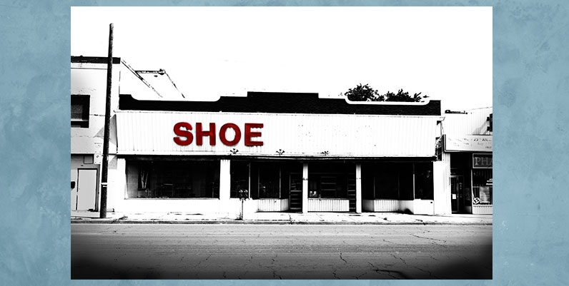 Special Exhibit Eileen Reilly black and white photo of a closed shoe store