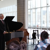 a man speaking behind a podium in front of a crowd