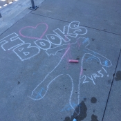 Chalk drawing of a child's outline with I heart books written above