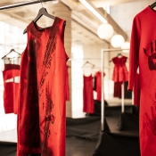 Two red dresses in focus with tire marks and handprints on them.