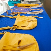 natural tan leather bags and dreamcatcher laid out on a blue table