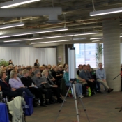 a photo of a group of people listening to a speaker