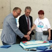 a photo of paul takala, mayor fred eisenberger andn suzanne fawcett cutting a cake