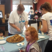 a group of people serving and eating cakes and cookies