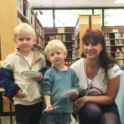 two boys and library staff posing for picture