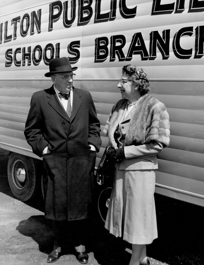 Archival photo of Mayor Lloyd D. Jackson and Freda Waldon, Chief Librarian standing next to the Bookmobile in 1961