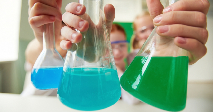 Science Programs Closeup of children holding beakers