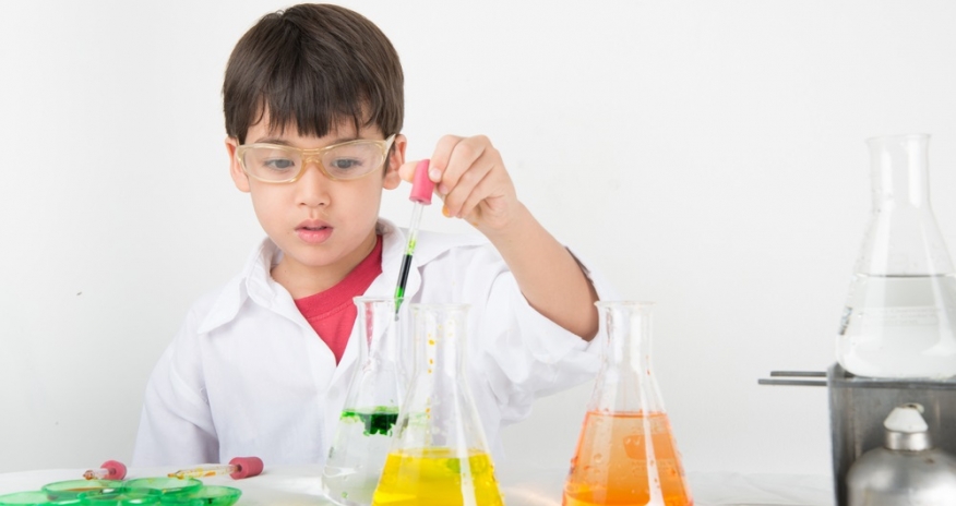 Boy doing a science experiment with lab beakers