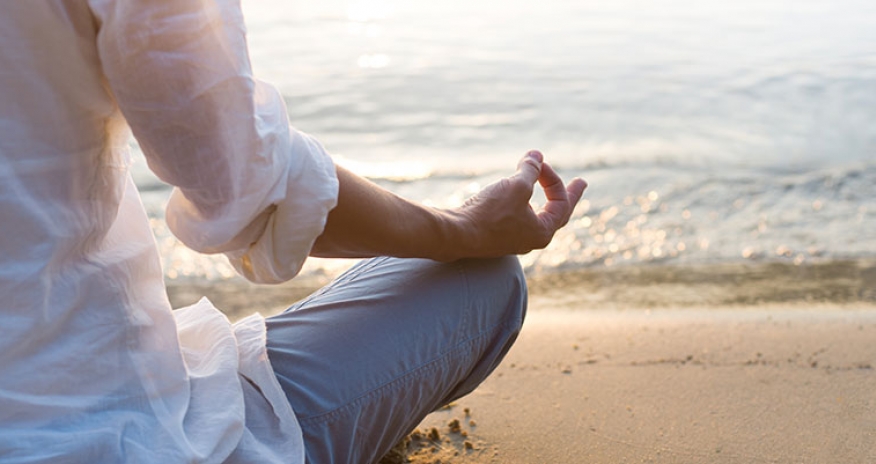 Spring Detox female meditating on a beach
